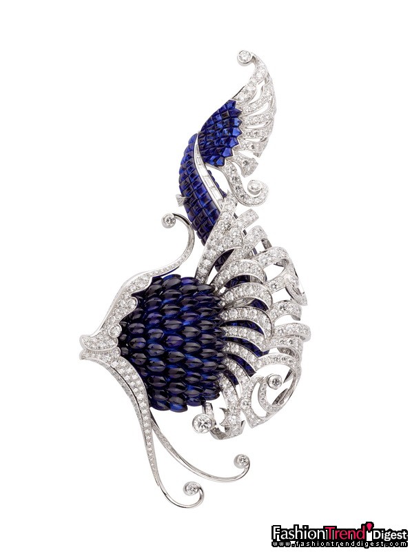 搜奇之师：Iliade胸针<br>
白金、钻石及隐密式镶嵌蓝宝石，2007年<br>
<br>
名字来自荷马史诗《奥德赛》的Iliade胸针揉合幻想与真实，纯洁、飘逸的曲线为亚特兰蒂斯的海岸线镀上耀眼的光辉。<br>
<br>
这枚L'Atlantide系列的巅峰之作上运用了两种隐密式镶嵌技术，冶炼出宝石潜藏的生命动感，恰到好处地凝住栩栩如生的神态。使用与Trésors Révélés系列chardon胸针相同的技术，Iliade胸针以榄形切割蓝宝石妆点魔幻鱼身，颗颗宝石鱼鳞辉映点点神秘光采；鱼鳍则运用了传统的隐密式镶嵌技术，网状细工将钻石衬托得更加璀璨；背鳍则由长方形切割钻石镶嵌。<br>
<br>
优质宝石揉合顶尖工艺，造就了这款饱含创造力的杰作。为达至和谐纯粹的色泽，五十多颗大号蓝宝石皆历经精挑萃选，方在工匠手中化作神话仙鱼。<br>
<br>
Iliade和chardon胸针展现了复杂的宝石切割和镶嵌工艺，榄形宝石镶嵌于V形金属轨道上，让颗颗鱼鳞的末端优雅隐密地固定于底部，缔造精巧的三维效果。色泽和材质缤纷多变的Iliade胸针能轻易成为目光焦点，蓝宝石和钻石交相辉映，焕发更璀璨纯粹的光芒。<br>
<br>
私人藏品 